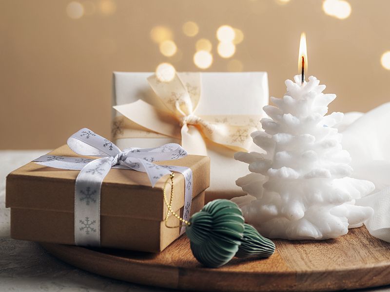 Vela al lado de cajas de regalo.